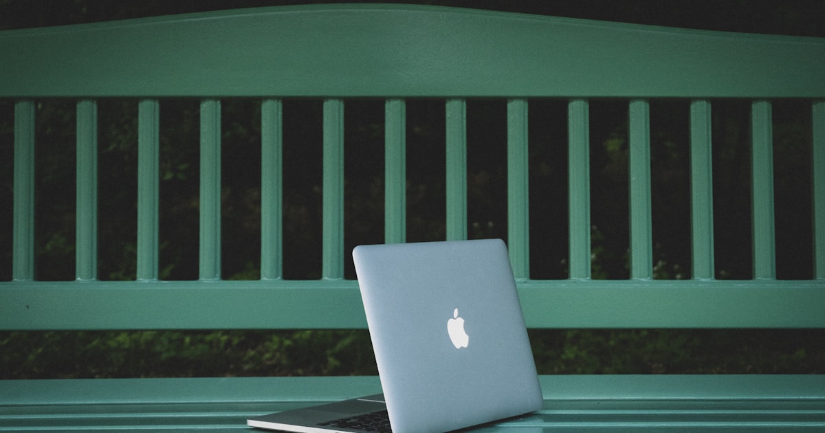 A laptop open on a garden bench — the kind of outdoor workspace that needs proper Wi-Fi